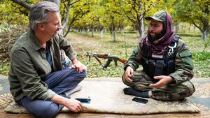 still uit de vpro-serie onze man bij de taliban, met Thoams erdbrink in gesprek met een talibanstrijder in een boomgaard